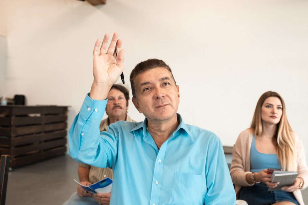 adult man in blue long sleeves raising his hand